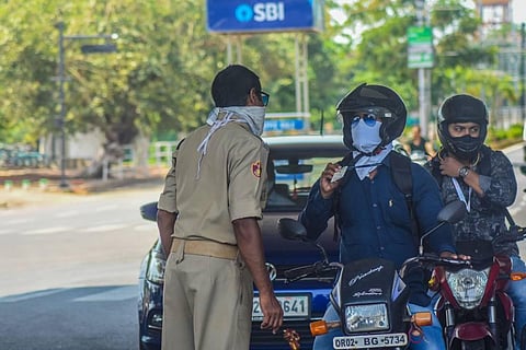 Commuters showing their ID cards to security personnel in Bhubaneswar. (Photo | Biswanathan Swain, EPS)