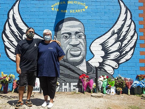 Artists Alex Roman, better known as Donkeeboy, and his mother Sylvia Roman, better known as Donkeemom, pose in front of their mural honoring George Floyd on Friday, June 5, 2020, in Houston. (Photo | AP)