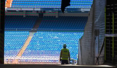 Workers walk into Real Madrid's Santiago Bernabeu stadium. (Photo | AP)
