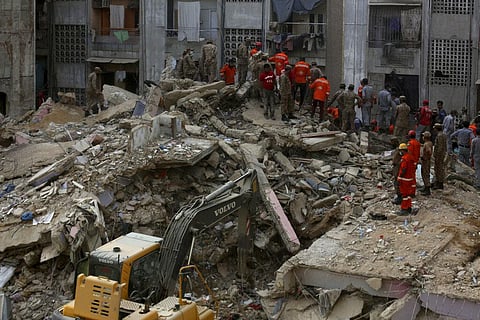 Pakistani troops, rescue workers and volunteers look for survivors amid the rubble of a collapsed building in Karachi, Pakistan, Monday. (Photo | AP)