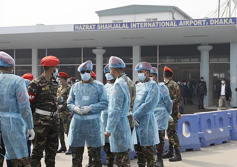Security personnel wearing protective gear wait for arrival of citizens who were brought back from Wuhan at Dhaka airport. (File photo | AP)
