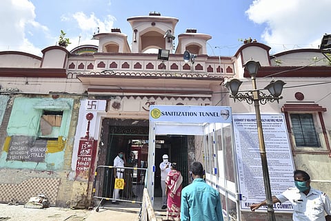Devotees pass through a sanitising tunnel as they enter Kalighat Kali temple after it reopened during Unlock 2.0 in Kolkata Wednesday July 1 2020. (Photo | PTI)