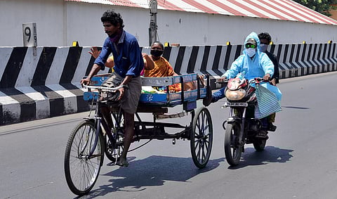 A motorist wearing PPE kit leveraging a tricycle at Periyamet. (Photo | R Satish Babu, EPS)