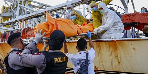 Officials transferring the body of an Indonesian crew member found on board following the search of a Chinese-flagged fishing vessel, at the navy port in Batam, Riau province. (Photo| AFP)