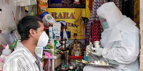 A shopkeeper wearing Protective suit and gear selling Pan in a view to protect himself and others from COVID-19 in Varanasi. (Photo| ANI)