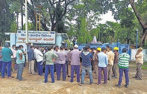 Employees stand outside VIL gate