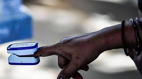 Oxygen level being measured on apulse oximeter at a screening centre. (Photo| AFP)
