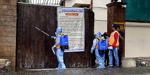 BMC workers sanitise the residence of Bollywood actor Amitabh Bachchan after he tested COVID-19 positive, in Mumbai. (File photo| ANI)