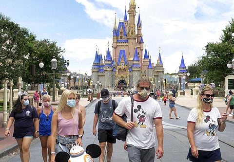 Guests wear masks as required to attend the official reopening day of the Magic Kingdom at Walt Disney World in Lake Buena Vista, Fla., Saturday, July 11, 2020. (Photo | AP)