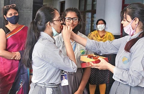 Students celebrate with sweets after the announcement of CBSE class 12th results in Gurugram on Monday (Photo | PTI)