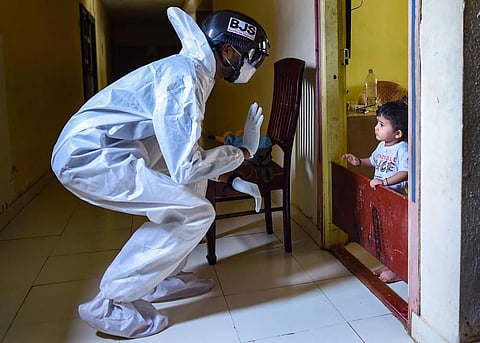 A medic conducts thermal screening with smart helmet of a resident of Kurar Village as coronavirus cases surge across the state in Mumbai. (Photo | PTI)