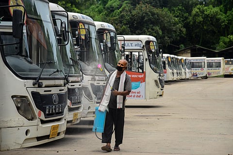 A worker sprays disinfectant on the buses parked at a depot during the total lockdown imposed to curb the spread of novel coronavirus in Patna Tuesday July 14 2020. (Photo | PTI)