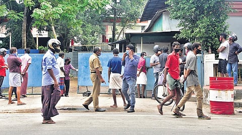 A policeman tries to disperse the crowd in front of a liquor outlet at Willingdon Island in Kochi. Such places are turning out to be high-risk areas with many flouting social distancing rules | Albin Mathew
