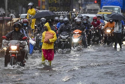 Commuters wade through a waterlogged street during monsoon rain at Sion in Mumbai Tuesday July 14 2020. (Photo | PTI)