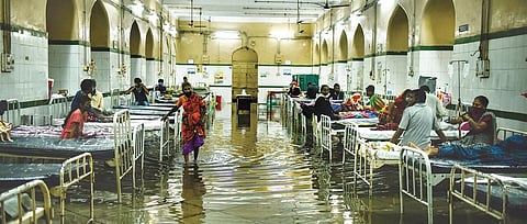 A woman wades through ankle-deep water in the flooded ground-floor ward of the Osmania General Hospital following incessant rains on Wednesday | VINAY MADAPU |