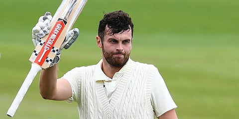 England's Dom Sibley raises his bat to celebrate scoring a century during the second day of the second cricket Test match between England and West Indies at Old Trafford in Manchester. (Photo | AP)