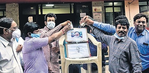 Members of the Medical JAC pour milk on Chief Minister K Chandrasekhar Rao’s photo as a mark of gratitude, in Hyderabad on Friday | Vinay Madapu