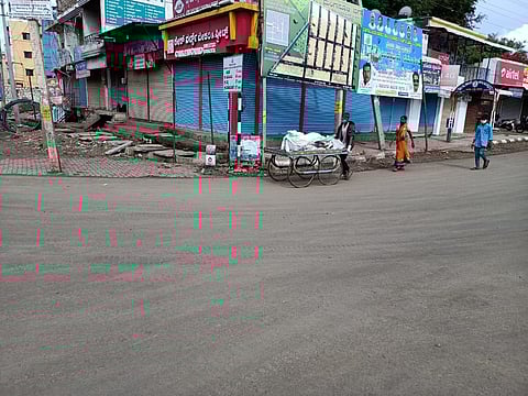 Woman with the help of daily wage carrying a body to crematorium using pull cart.