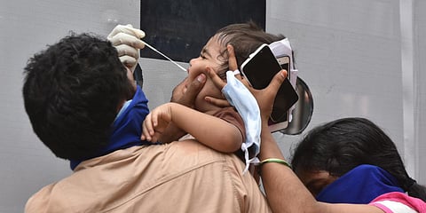 Medical staff collecting sample from a kid for COVID-19 test at IGMC stadium in Vijayawada on Friday. (Photo| P Ravindra Babu, EPS)