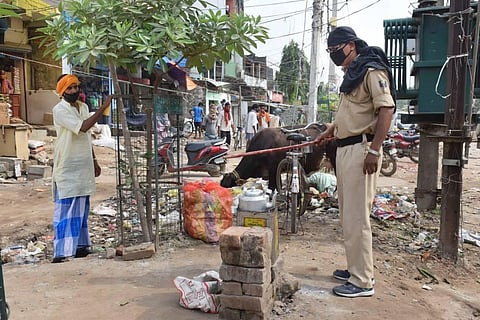A security person attempts to remove a roadside tea stall during the total lockdown in Patna Saturday July 18 2020. (Photo | PTI)