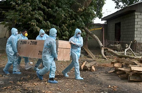 CRPF personnel and health workers wearing PPE kits carry the mortal remains of an officer who died of COVID-19 during his cremation in Srinagar Saturday July 18 2020. (Photo | PTI)