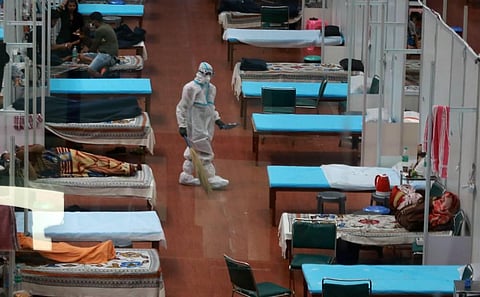 A worker wearing PPE kit cleans a ward at CWG Village COVID-19 Care Centre near Akshardham in New Delhi on Sunday. (Photo | Shekhar Yadav/EPS)