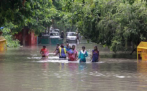 People wade on a flooded road following rains in New Delhi. (Photo | Shekhar Yadav, EPS)