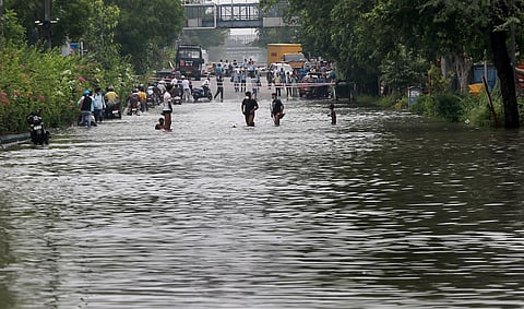 People wade on a flooded road following rains in New Delhi (Photo | Shekhar Yadav, EPS)