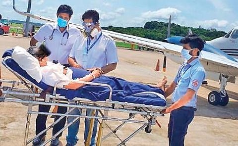 The patient being checked by on-ground medical staff upon landing in Kochi