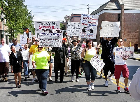 Demonstrators carry signs in Martinsburg, W.Va., as they protest the killing of Winchester, Va., resident Wayne Jones by Martinsburg police on March 13, 2013. (Photo | AP)