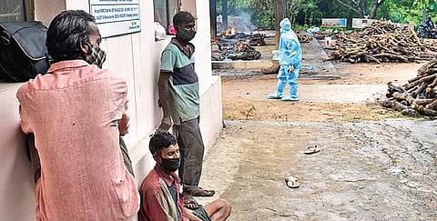 Daily wage workers take a break after helping in the cremation of Covid-19 victims (Photo | S Senbagapandiyan, EPS)