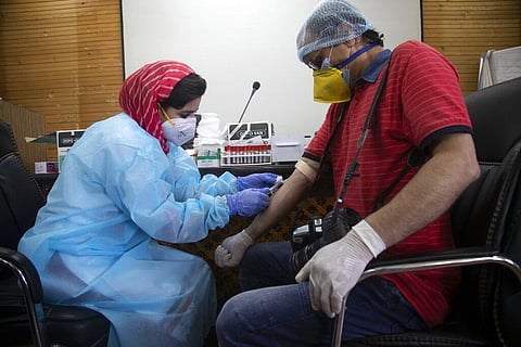 A Kashmiri medical staff collects blood samples of a Kashmiri photojournalist for a COVID-19 antibody test in Srinagar. (File photo| AP)