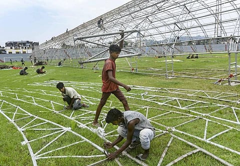 Workers construct a temporary quarantine facility for COVID-19 patients at Nehru Stadium in Guwahati. (Photo | PTI)