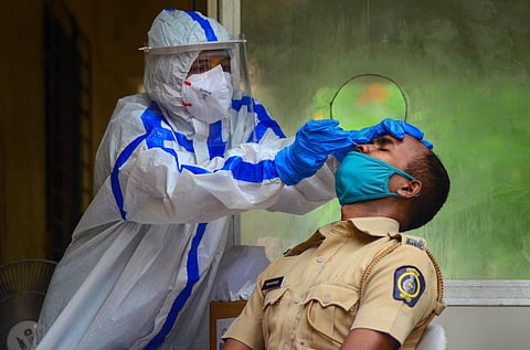 Panvel City Municipal Corporation doctor collects swab sample of a policeman for Rapid Antigen Test in Navi Mumbai. (Photo | PTI)