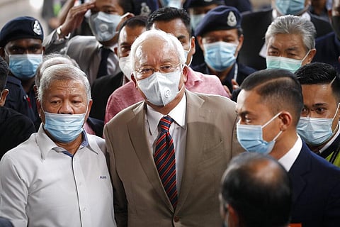 Former Malaysian Prime Minister Najib Razak, center, wearing a face mask with his supporters arrives at courthouse in Kuala Lumpur, Malaysia. (Photo | AP)