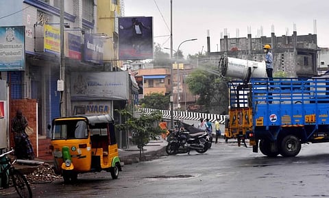 A corporation worker sprays disinfectant onto shops at Vyasarpadi in Chennai on Wednesday. (Photo | Debadatta Mallick/EPS)