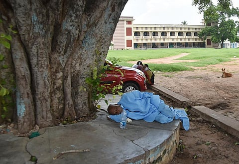 A sanitation worker taking rest during break time at COVID-19 testing centre at Gunadala in Vijayawada. (Photo | P Ravindra Babu, EPS)