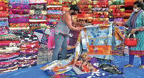 With restrictions eased, streetside vendors are back in business. A blanket seller attends to a customer in Bengaluru on Thursday, which is seeing a dip in temperature | meghana sastry