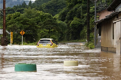 A car is stuck in a flooded road by heavy rain in Yatsushiro, Kumamoto prefecture, southwestern Japan. (Photo | AP)