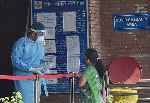 A health worker wearing protective suits interacts with a relative at LNJP hospital during the Unlock 2.0 in New Delhi Friday July 3 2020. (Photo | PTI)