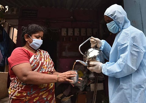 An Chennai corporation employee serves 'Kabasurakudineer' to a resident of Porur at their doorstep to prevent Corona. (Photo | P Jawahar, EPS)