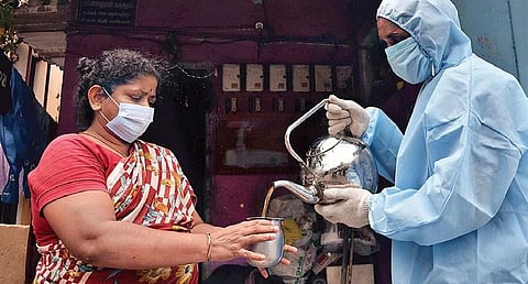 A city corporation staff giving ‘kabasura kudineer’ (a herbal concoction), which is believed to boost immunity, to a resident in Porur on Sunday | P Jawahar
