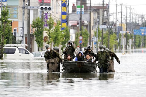 Japan Self Defense Force members rescue residents on a boat on a flooded road hit by heavy rain in Omuta, Fukuoka prefecture, southern Japan Tuesday, July 7, 2020. (Photo | AP)