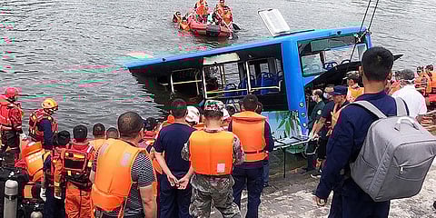 Rescuers watch as a bus that fell into a lake is recovered in the Xixiu District of Anshun, southwestern China's Guizhou Province. (Photo| Xinhua via AP)