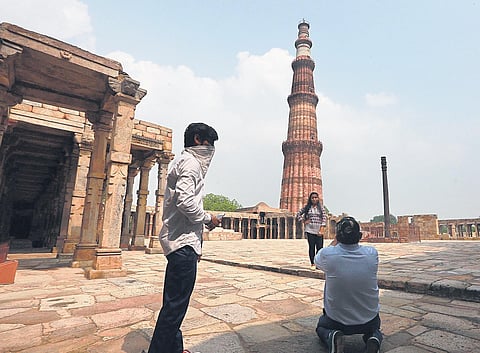 Visitors click pictures near Qutub Minar on Monday, when monuments were reopened for public | Shekhar Yadav