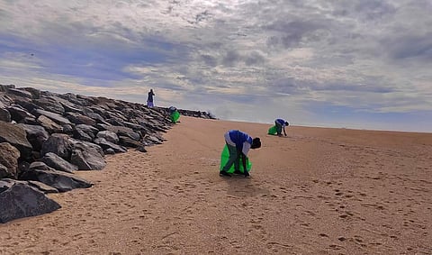 Workers cleaning Kovalam beach. (Photo | Express)