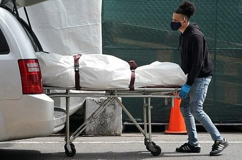 A body is moved from a refrigeration truck serving as a temporary morgue to a vehicle at the Brooklyn Hospital Center (Photo| AFP)