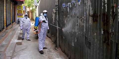 A corporation worker sprays disinfectant at a narrow lane at Aminjikarai in Chennai. (Photo| Debadatta Mallick, EPS)