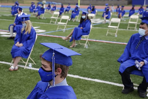 Graduating students practice socially distance by sitting far apart during a graduation ceremony at Millburn High School in Millburn, N.J., Wednesday, July 8, 2020. (Photo | AP)