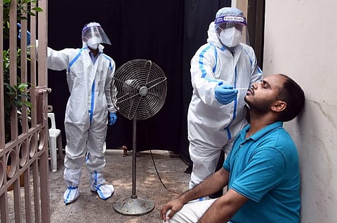A health worker takes a swab sample for Covid-19 testing at Defence Colony in New Delhi. (Photo | Parveen Negi/EPS)